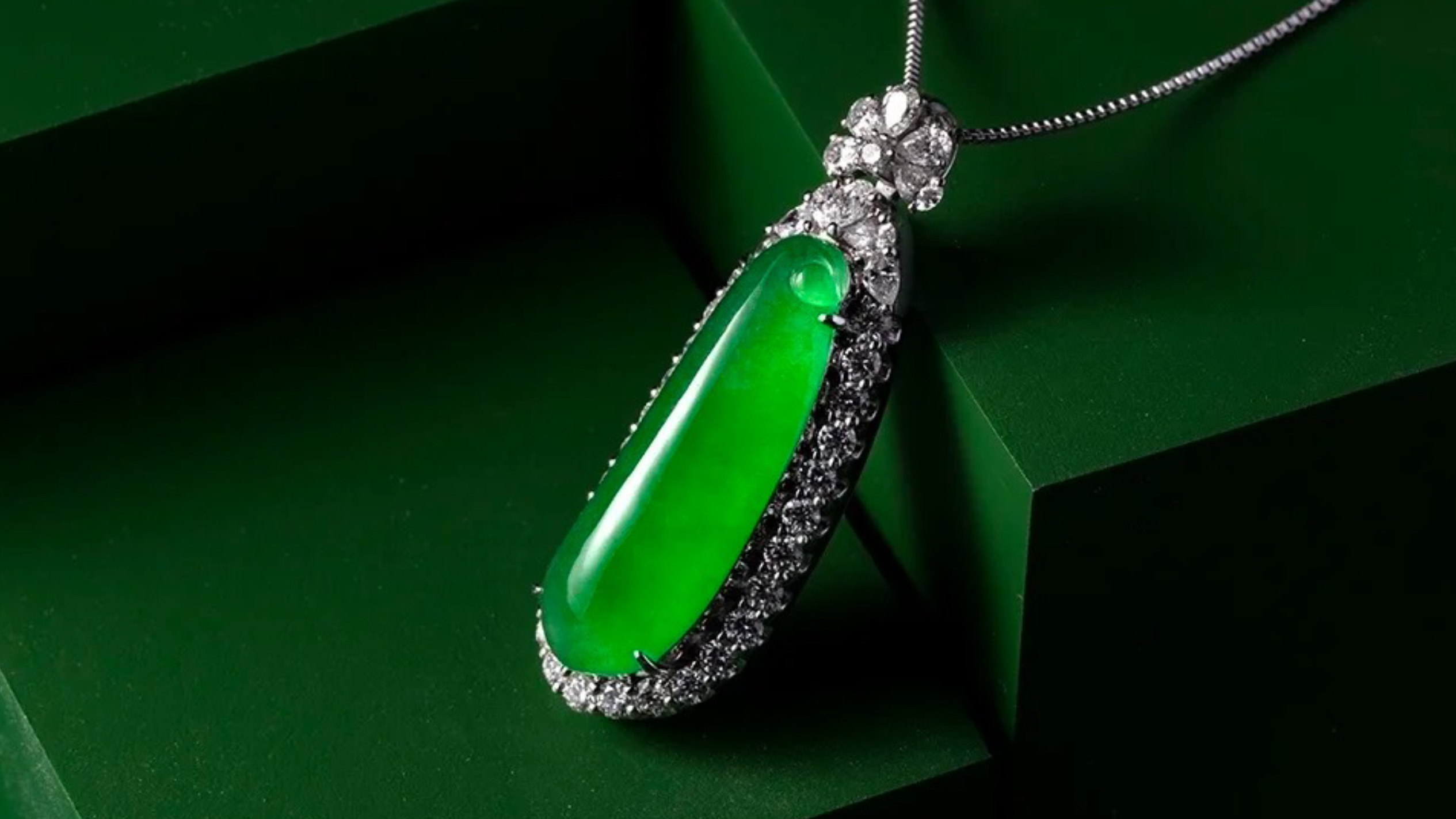 Green jadeite pendant on a dark green surface